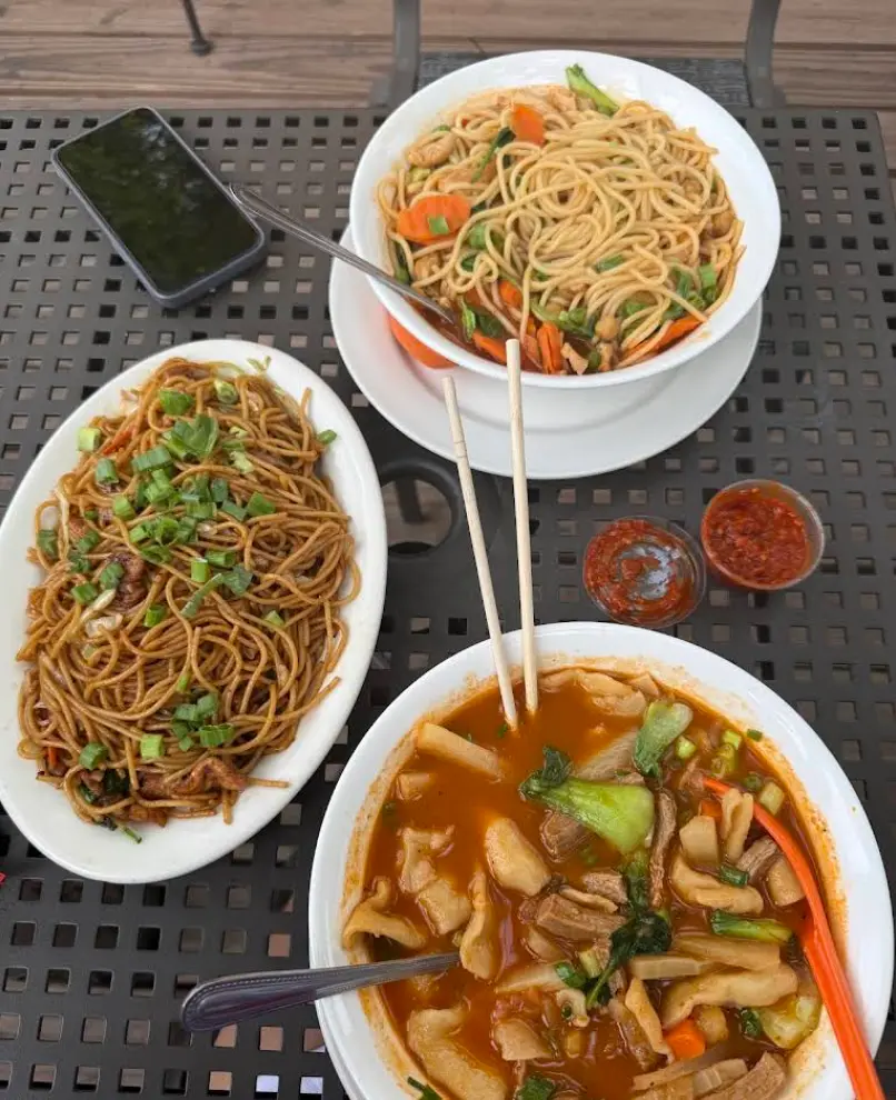 Tibet Kitchen fried noodles and thenthuk hand-pulled soup on patio table in Boulder CO