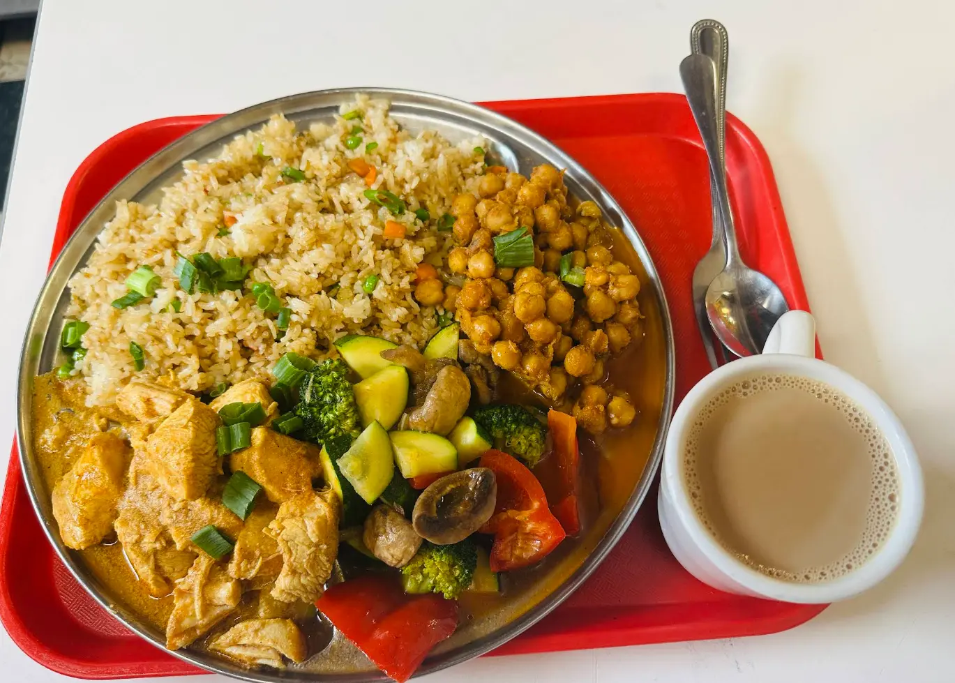 Tibet Kitchen lunch plate with fried rice, chickpeas curry, vegetables, chicken curry and chai in Boulder CO