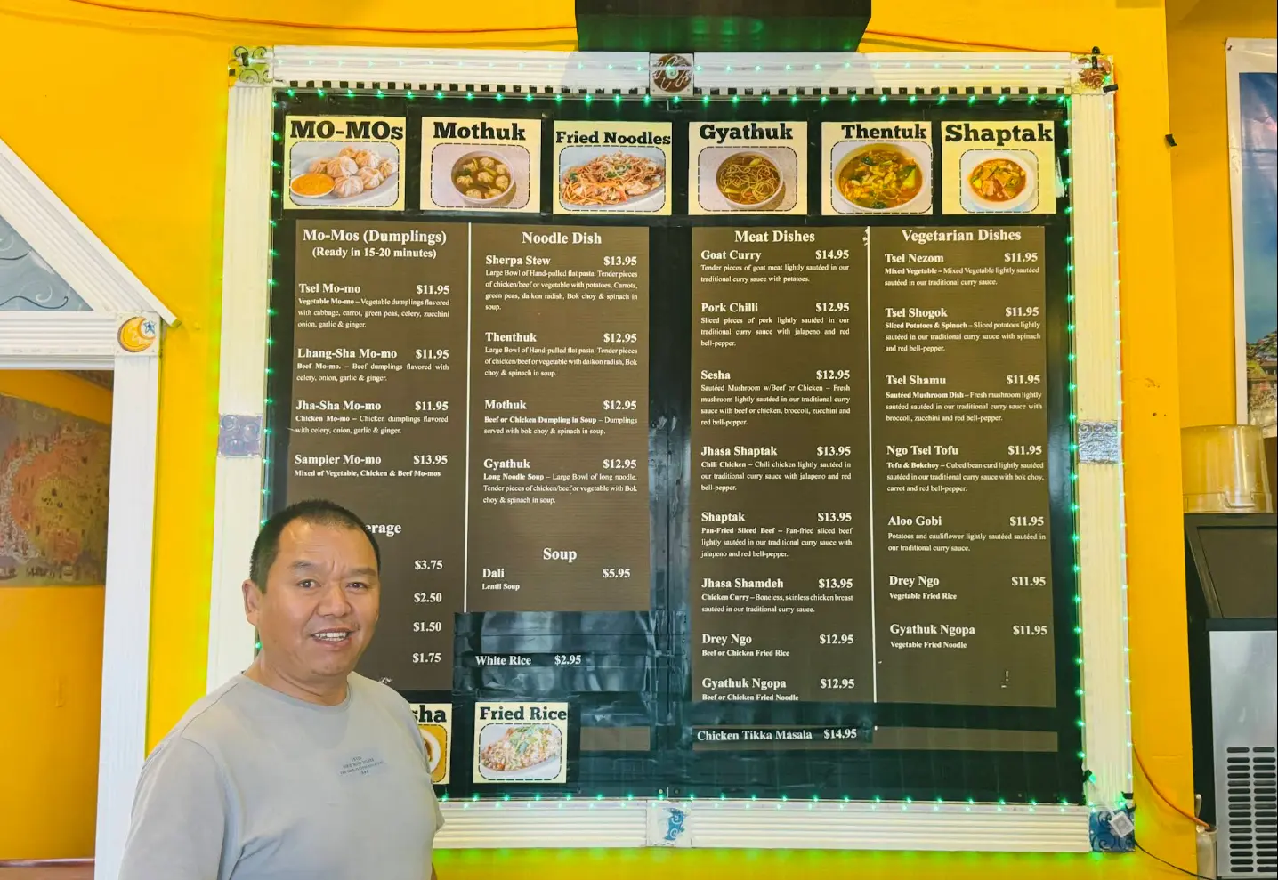 Tibet Kitchen restaurant menu board with owner at 2359 Arapahoe Ave, Boulder CO